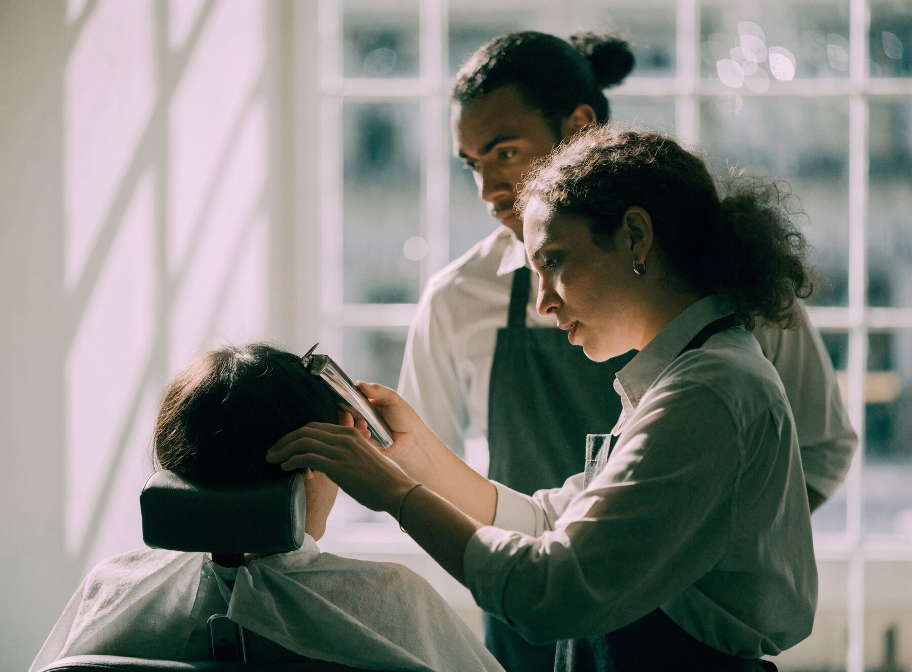 One barber watching another work